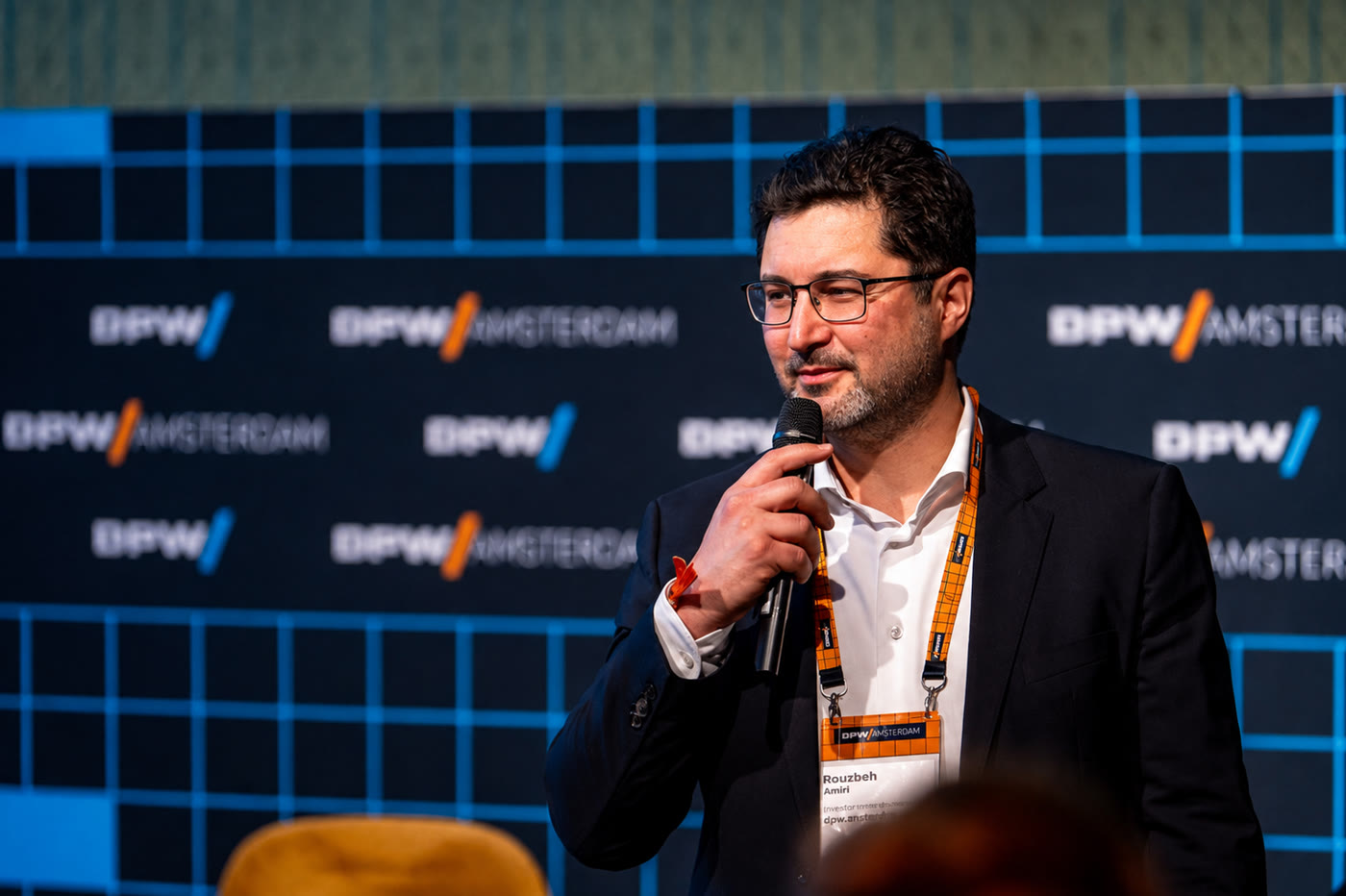 Rouzbeh Amini speaking on stage at DPW Amsterdam 2025